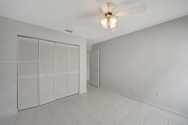 unfurnished bedroom featuring a textured ceiling, ceiling fan, visible vents, baseboards, and a closet