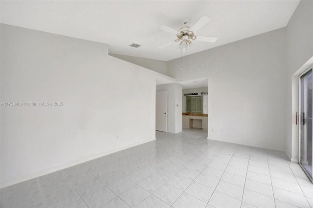 empty room with vaulted ceiling, light tile patterned flooring, visible vents, and a ceiling fan