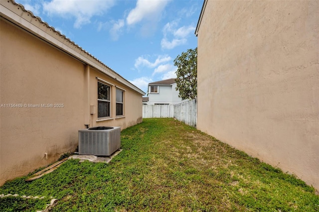 view of yard with cooling unit and fence