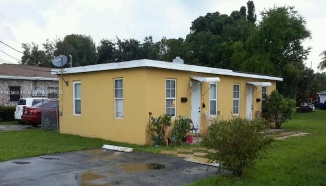 view of front facade featuring a front lawn and stucco siding