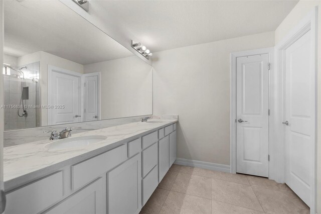 3142 Poinciana St, Lauderdale Lakes, FL 33311 - bathroom with baseboards, a tile shower, double vanity, and a sink