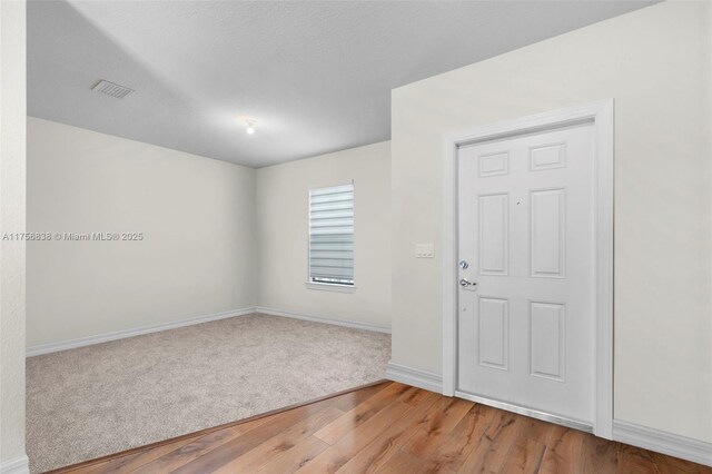 3142 Poinciana St, Lauderdale Lakes, FL 33311 - unfurnished room with light colored carpet, baseboards, visible vents, and light wood-style floors