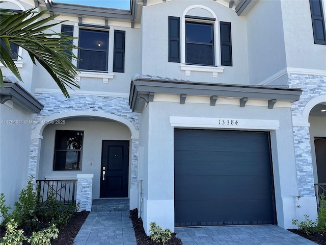 13384 SW 287th St, Homestead, FL 33033 - view of front facade with a garage, stone siding, decorative driveway, and stucco siding
