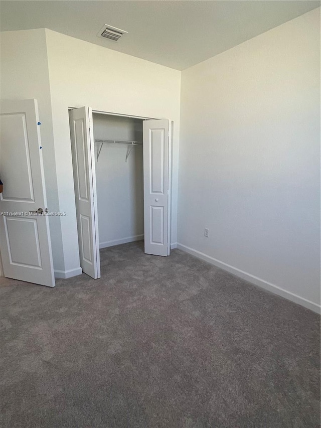 unfurnished bedroom featuring a closet, carpet flooring, visible vents, and baseboards