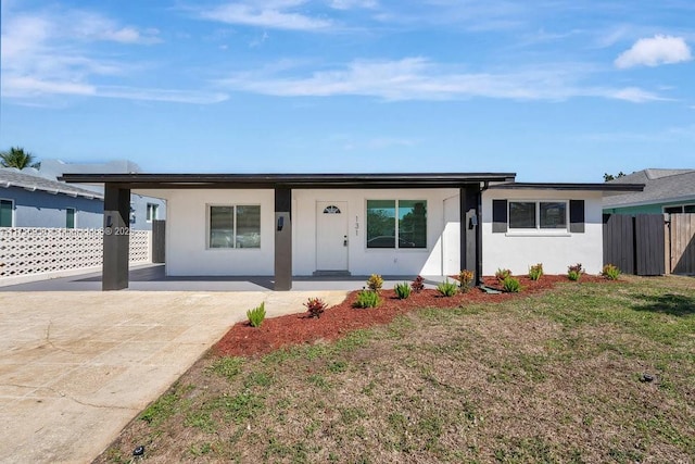 single story home featuring a front lawn, fence, and stucco siding