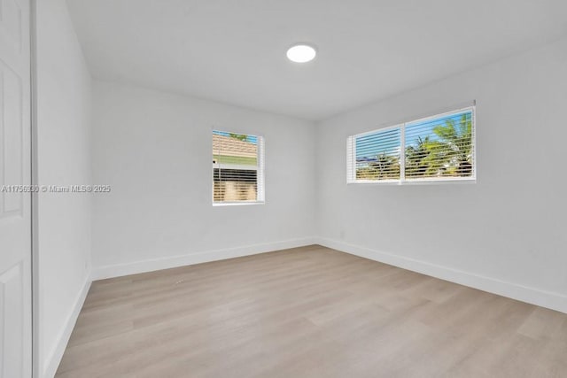 spare room with light wood finished floors and baseboards