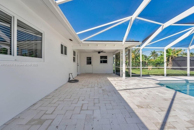 view of patio with a ceiling fan, glass enclosure, and an outdoor pool