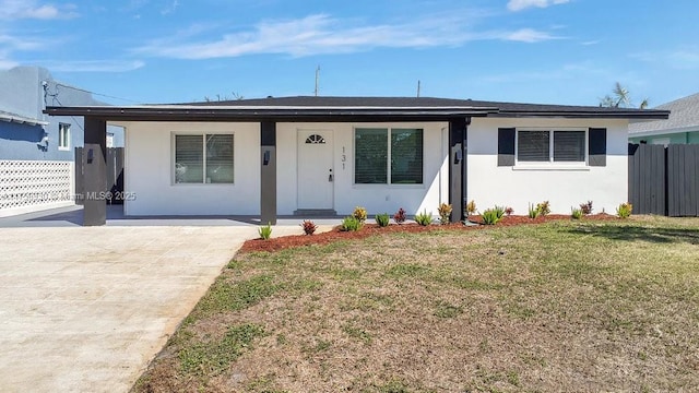 view of front facade featuring covered porch, a front yard, fence, and stucco siding