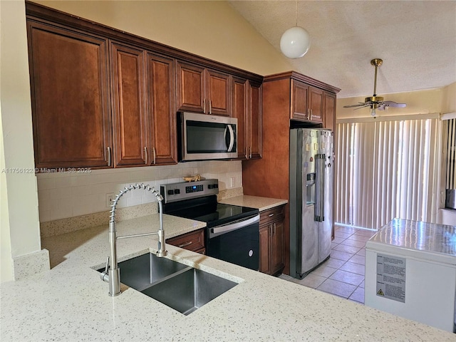 kitchen with light tile patterned floors, backsplash, appliances with stainless steel finishes, vaulted ceiling, and a sink