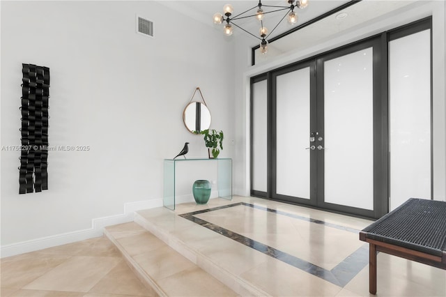 foyer with a chandelier, french doors, visible vents, and baseboards