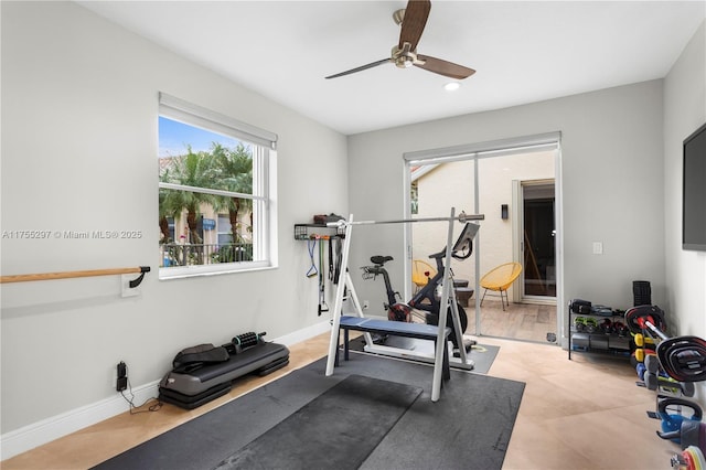 workout area featuring ceiling fan and baseboards