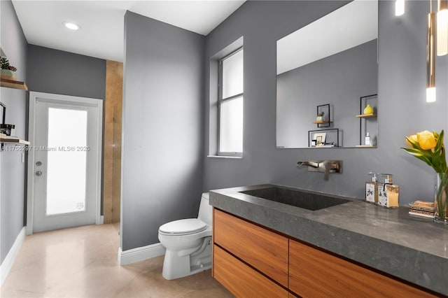 bathroom featuring tile patterned floors, vanity, toilet, and baseboards