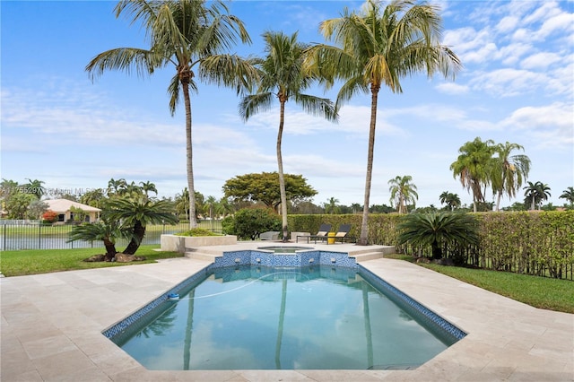 view of swimming pool featuring a patio area, fence, and a pool with connected hot tub