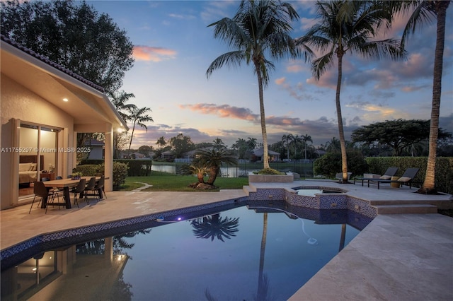 view of swimming pool featuring a patio, fence, and a pool with connected hot tub