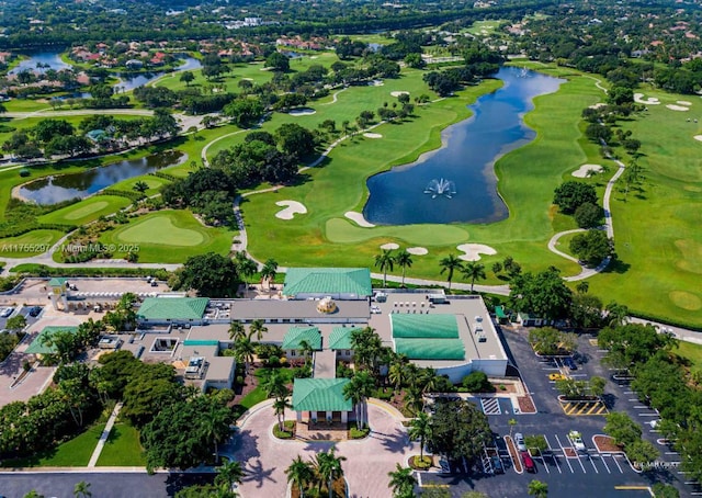 drone / aerial view featuring golf course view and a water view