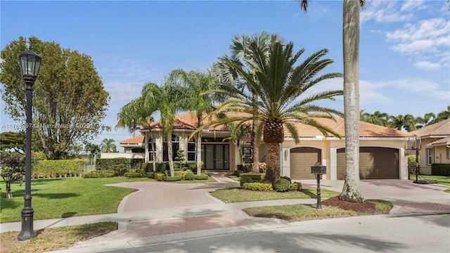 view of front of property featuring a garage, concrete driveway, stucco siding, a tile roof, and a front yard