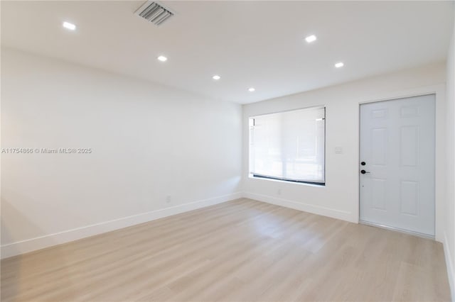 empty room featuring recessed lighting, baseboards, visible vents, and light wood finished floors