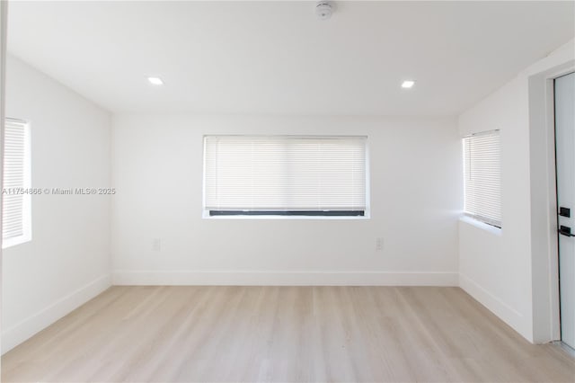 empty room featuring light wood finished floors, recessed lighting, and baseboards