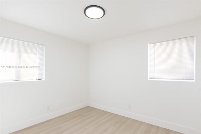 empty room with light wood-style flooring and baseboards