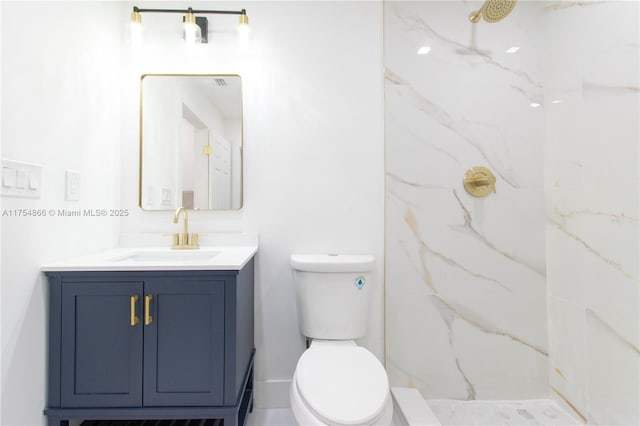 bathroom with toilet, vanity, and a marble finish shower