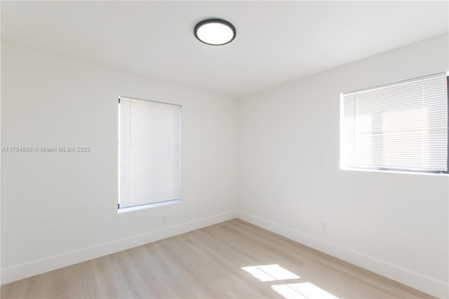 unfurnished room with light wood-style floors and baseboards