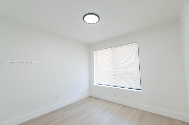 unfurnished room featuring light wood-style flooring and baseboards