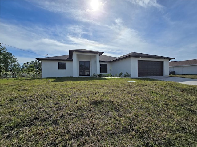 view of front of house with an attached garage, a front lawn, concrete driveway, and stucco siding