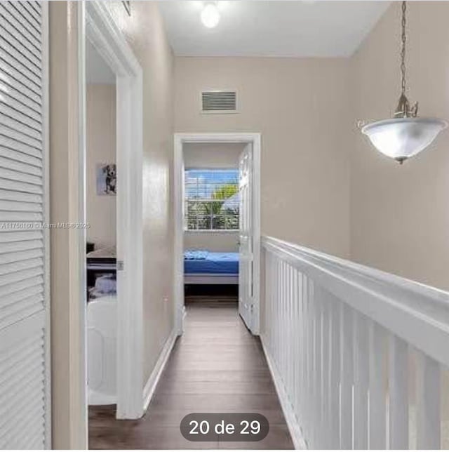 hall featuring wainscoting, visible vents, and dark wood finished floors