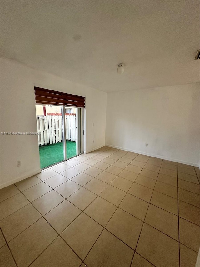 spare room featuring baseboards and tile patterned floors