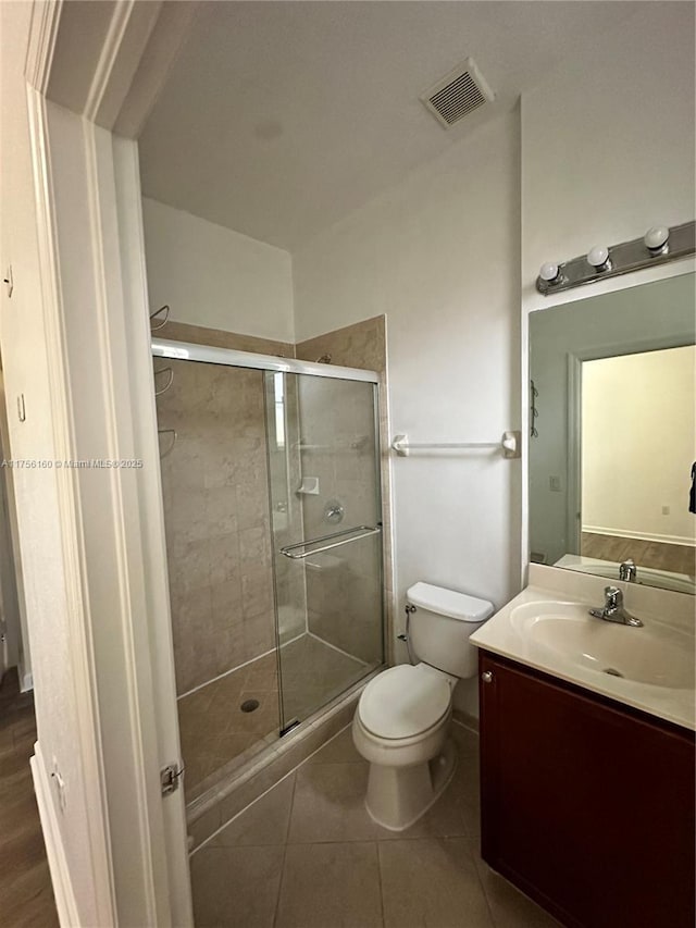 bathroom with visible vents, toilet, tile patterned floors, vanity, and a shower stall