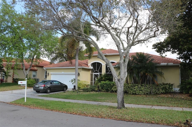 view of front of house featuring a tile roof, stucco siding, concrete driveway, a front yard, and a garage