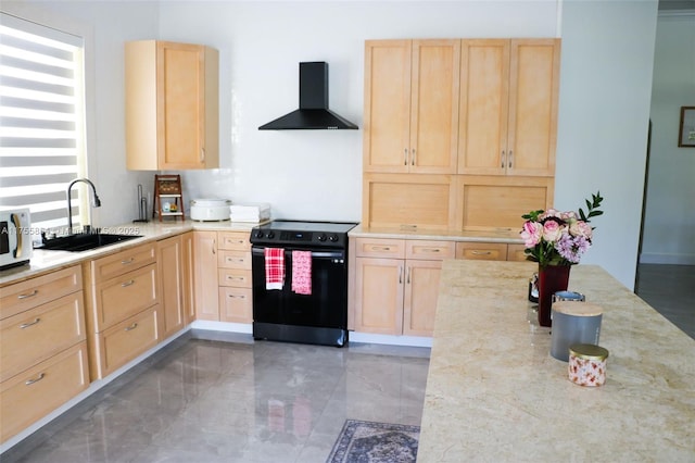 kitchen with light stone counters, a sink, black electric range, wall chimney range hood, and light brown cabinetry