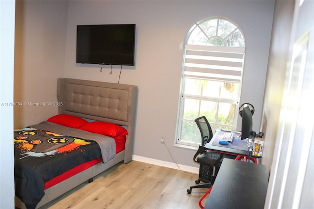 bedroom featuring baseboards and wood finished floors