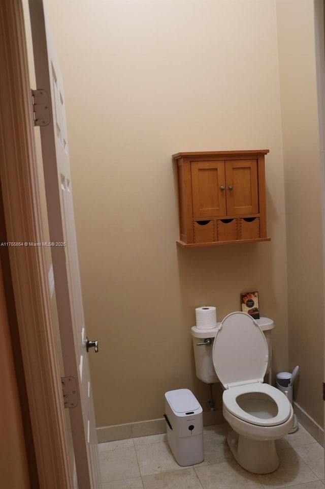 bathroom with toilet, tile patterned flooring, and baseboards