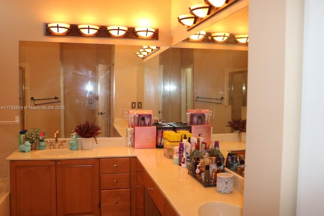 bathroom with double vanity, walk in shower, and a sink