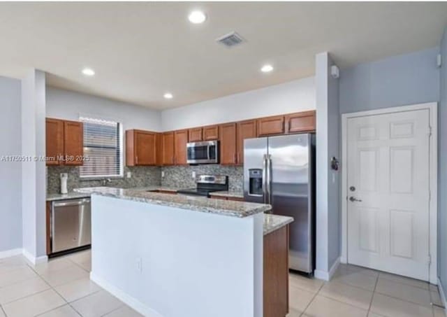 kitchen with light tile patterned floors, visible vents, stainless steel appliances, and backsplash