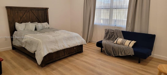 bedroom with light wood-type flooring and baseboards