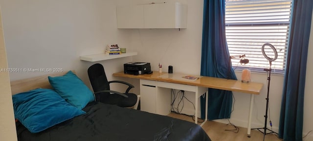 bedroom with light wood-style floors and built in desk