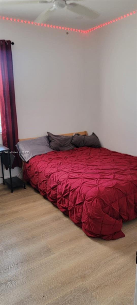 bedroom with a ceiling fan and wood finished floors