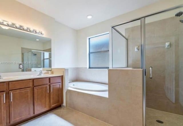 full bath with double vanity, a stall shower, a garden tub, tile patterned flooring, and a sink