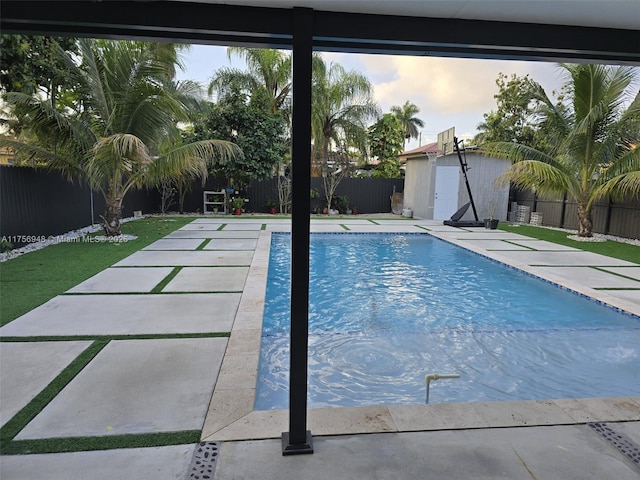 view of pool with a fenced in pool, a shed, a fenced backyard, a patio area, and an outbuilding