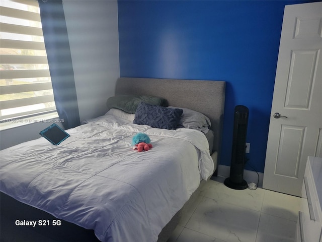 bedroom featuring marble finish floor