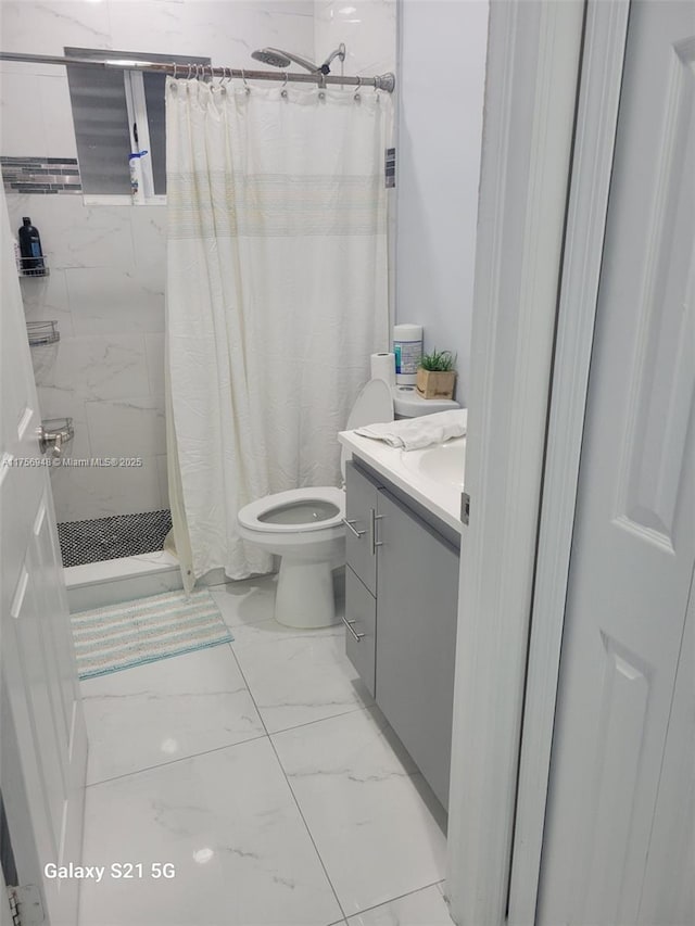 full bathroom with toilet, marble finish floor, a stall shower, and vanity