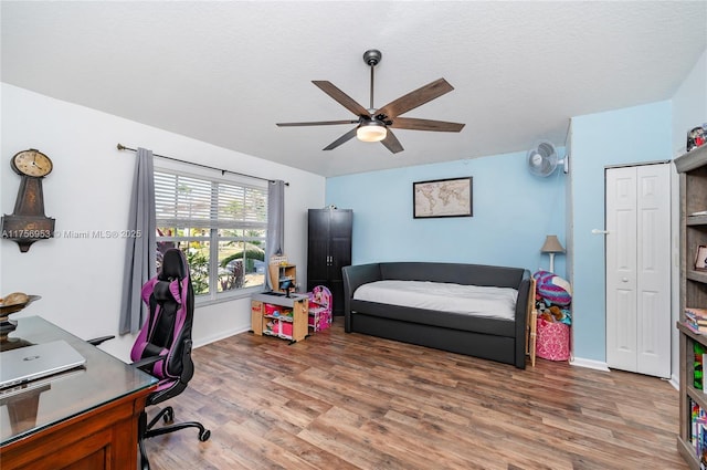 office area featuring ceiling fan, a textured ceiling, baseboards, and wood finished floors