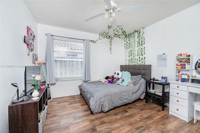 bedroom with ceiling fan, baseboards, and wood finished floors