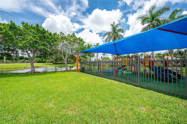 view of yard with a water view, fence, and playground community