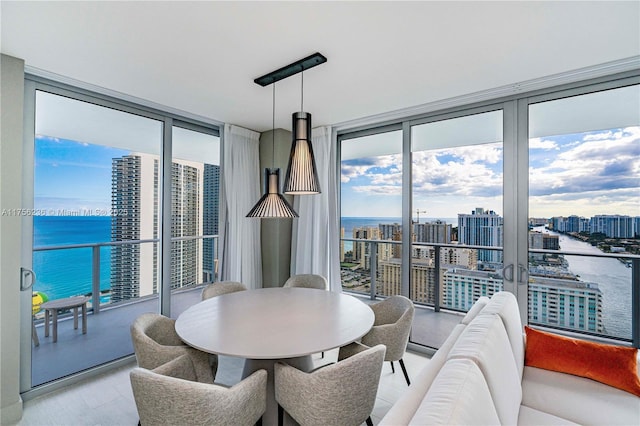 dining room with plenty of natural light, a water view, and floor to ceiling windows