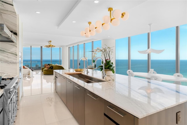 kitchen featuring a large island, open floor plan, light tile patterned flooring, a sink, and modern cabinets