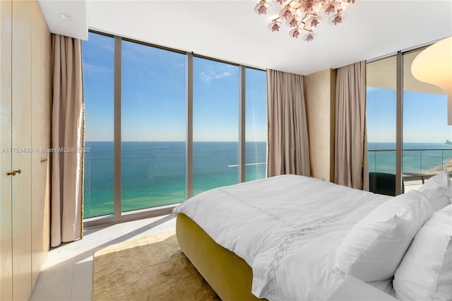 bedroom with expansive windows and a water view