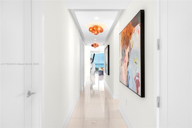 hallway with light tile patterned floors and baseboards